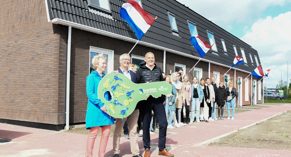 Sigrid Hoekstra, Roland van der Klauw en Biense Dijkstra samen met de nieuwe bewoners van Buurblok
