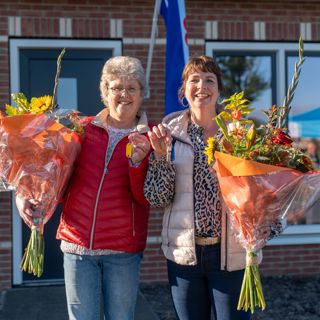 Twee nieuwe bewoners  voor hun huis ontvangen bloemen en sleutels van WoonFriesland